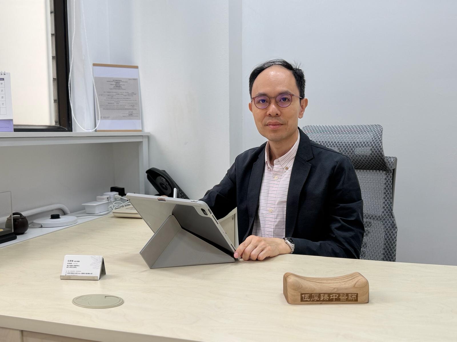 伍厚臻中醫師於診症室把脈